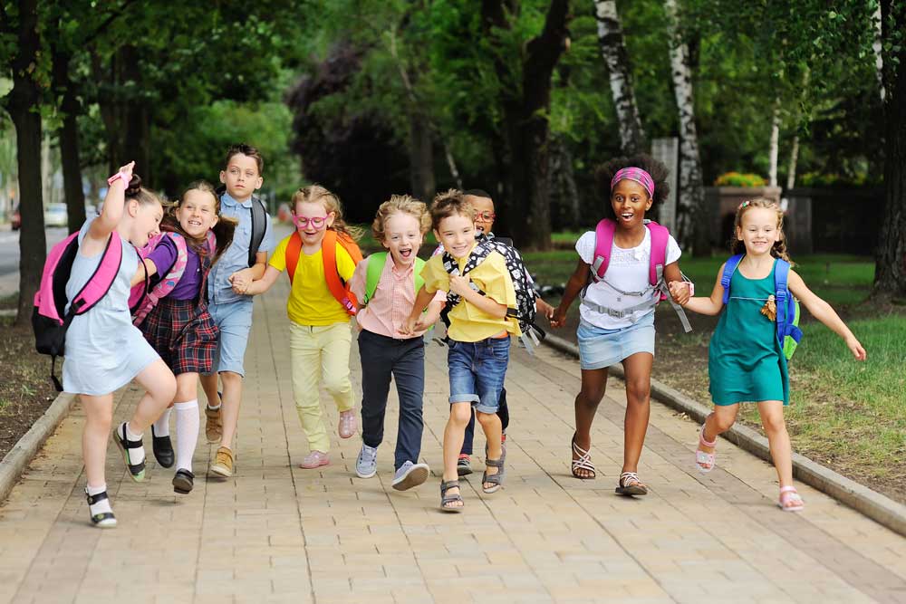 group of children with backpacks running