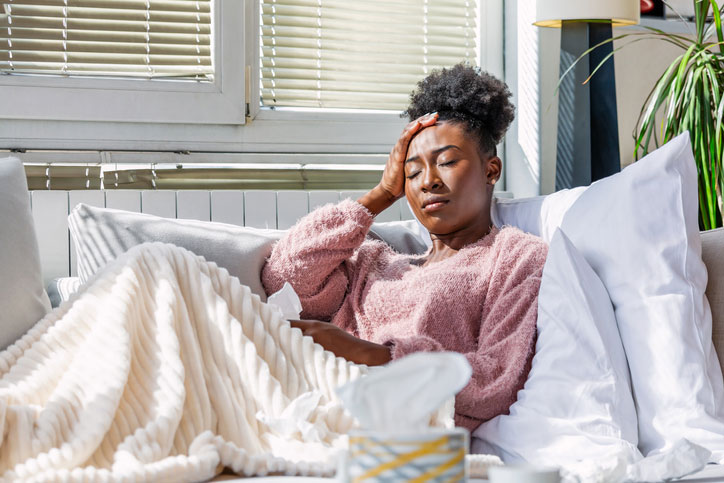 sick woman on bed with tissues around her