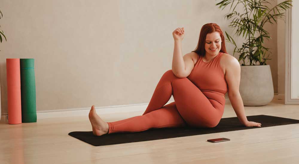 woman in yoga pose with phone open