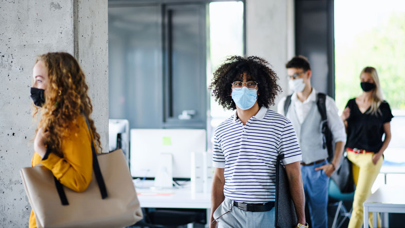 group of interns wearing masks enter office building