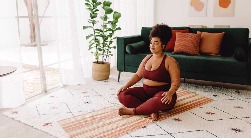 woman sitting crosslegged in sunny room